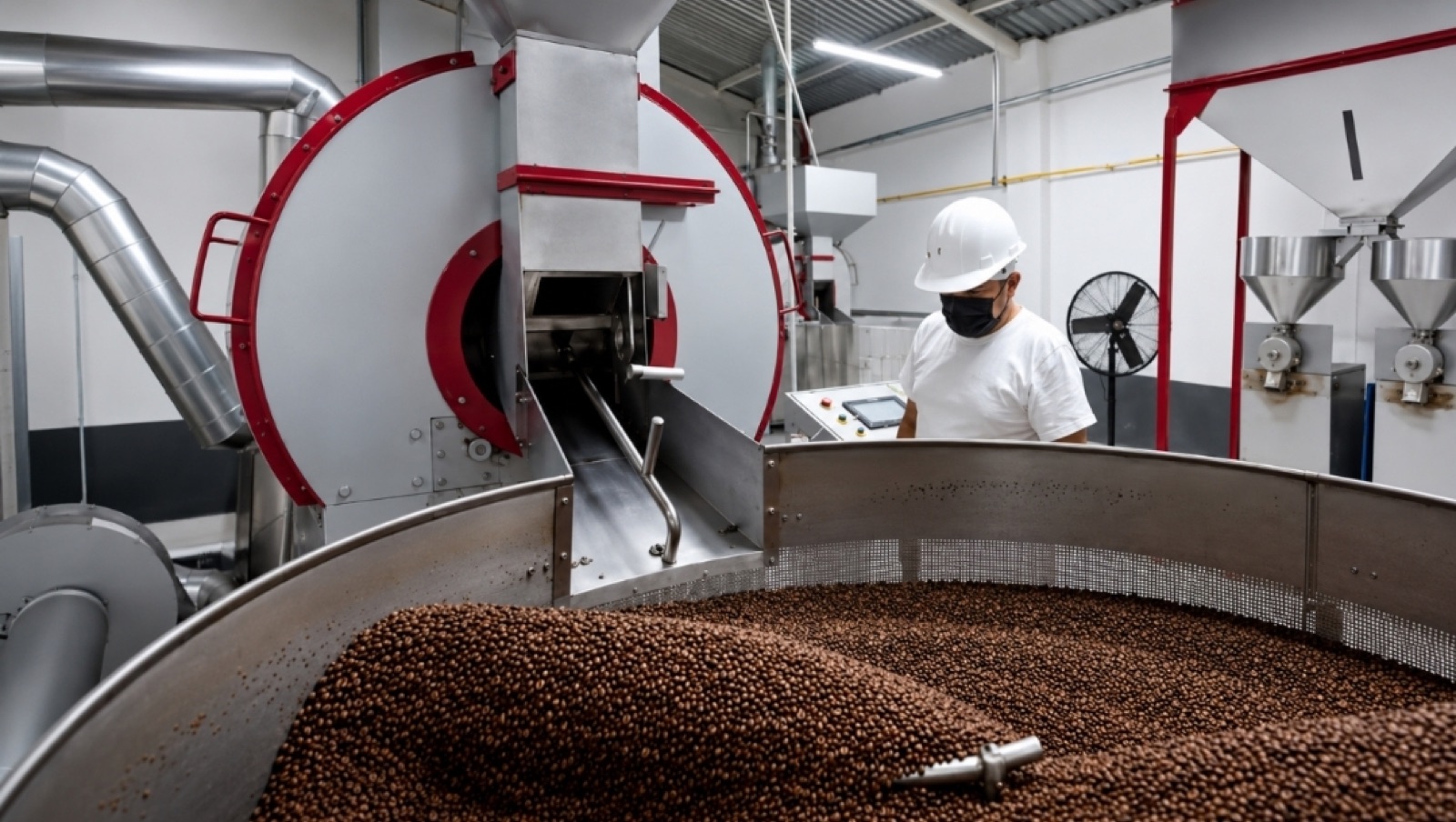 Operario supervisando el tostador industrial de café en la planta de Coatepec